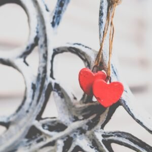 Two small red hearts on a string hanging on an ornamental bench